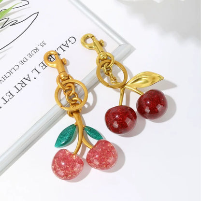 Llavero de cereza roja con charm para bolso y mosquetón dorado en forma de hoja