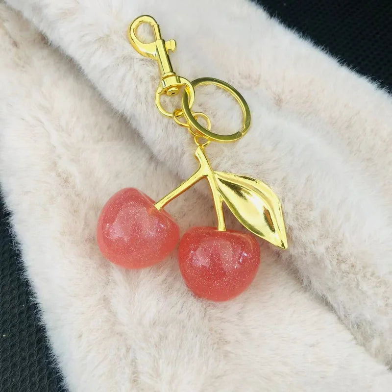 Llavero de cereza roja con charm para bolso y mosquetón dorado en forma de hoja