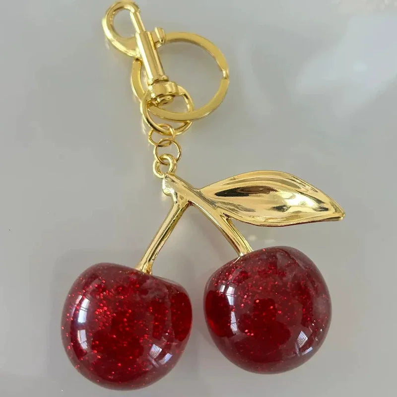 Llavero de cereza roja con charm para bolso y mosquetón dorado en forma de hoja