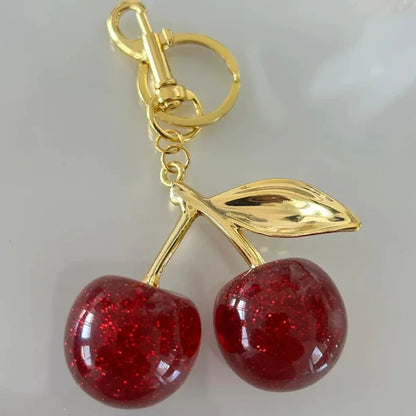 Llavero de cereza roja con charm para bolso y mosquetón dorado en forma de hoja